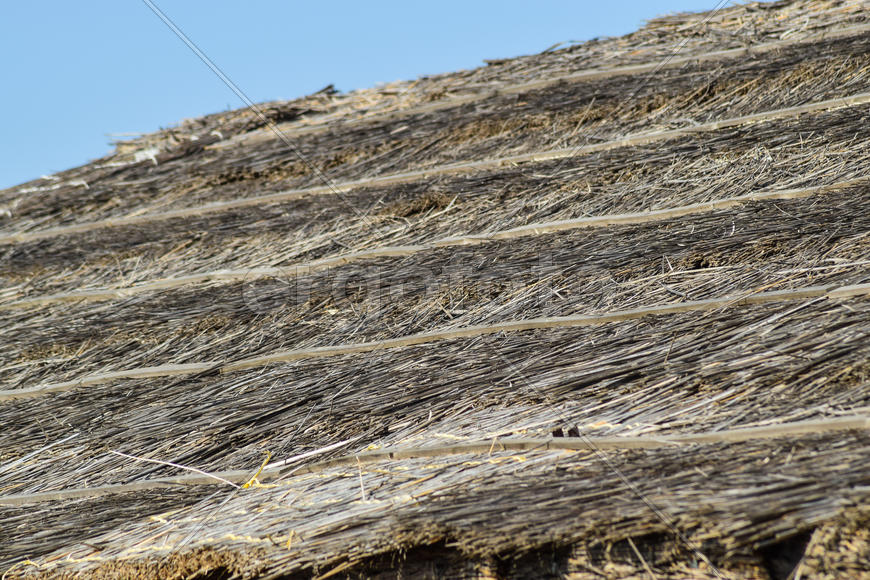 Наклон крыши из камыша и соломы. Древние строительные материалы.