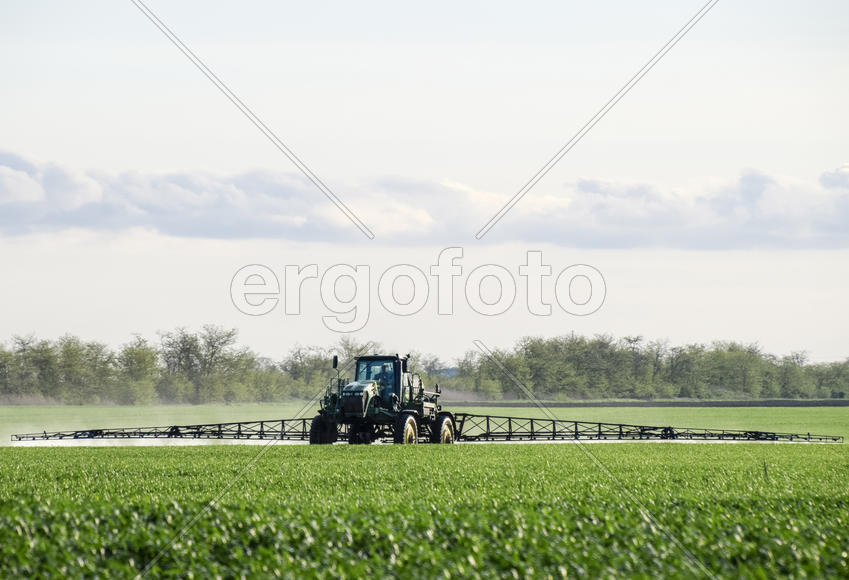 Трактор, распыляющий гербициды в поле, Краснодарский край, Россия