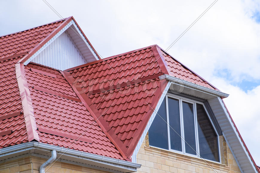 The house with plastic windows and a roof of corrugated sheet.