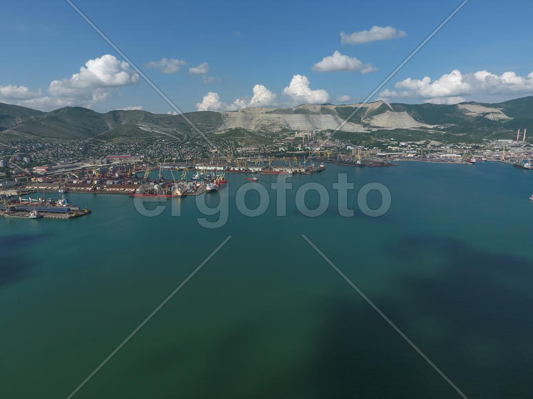 Industrial seaport, top view. Port cranes and cargo ships and barges. Loading and shipment of cargo 