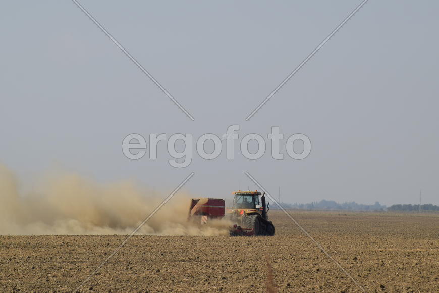 Russia, Temryuk - 19 July 2015: Tractor rides on the field and makes the fertilizer into the soil. C