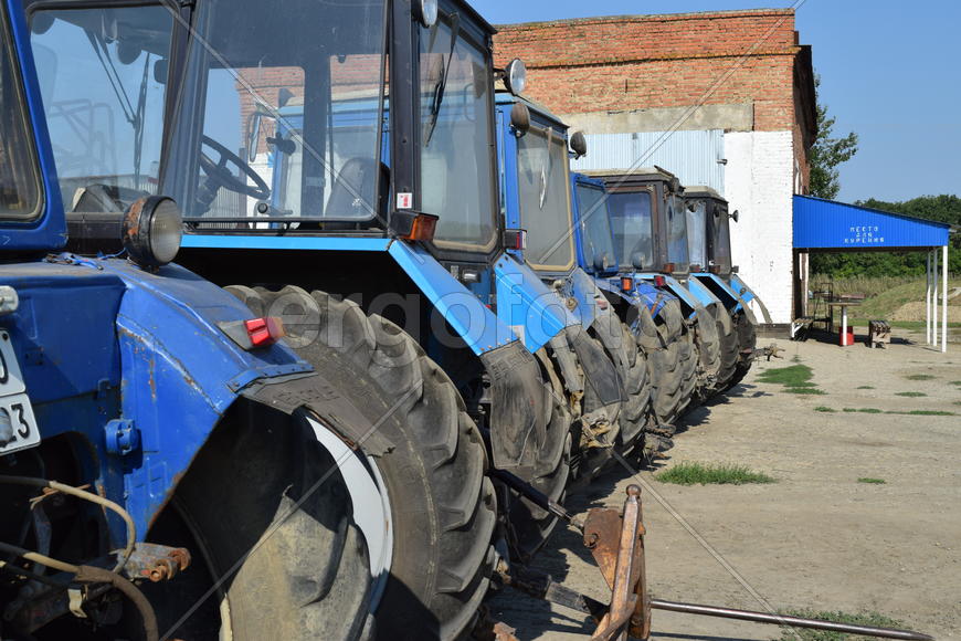 Tractor, standing in a row. Agricultural machinery. Parking of agricultural machinery.
