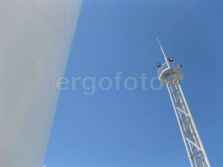 White tank and tower lighting on the sky background. Equipment for primary oil refining