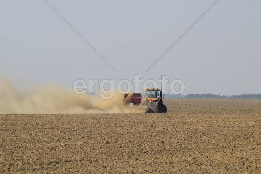 Russia, Temryuk - 19 July 2015: Tractor rides on the field and makes the fertilizer into the soil. C