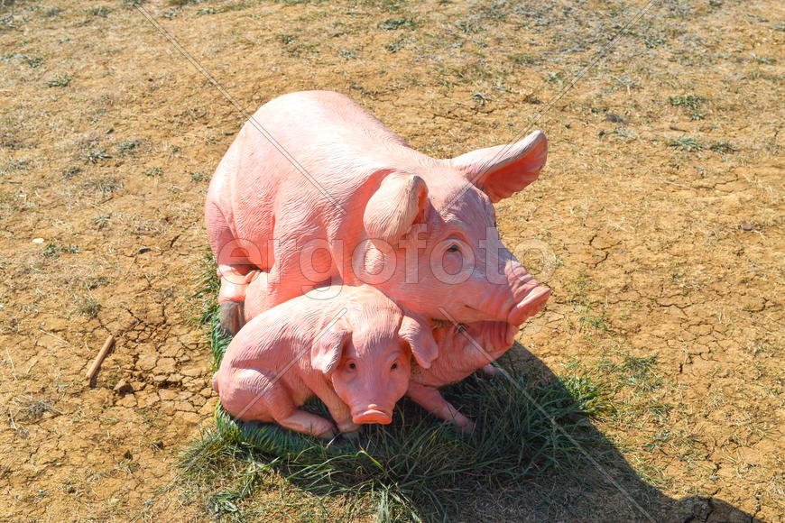 Декоративная фигурка свиньи с поросятами в саду 