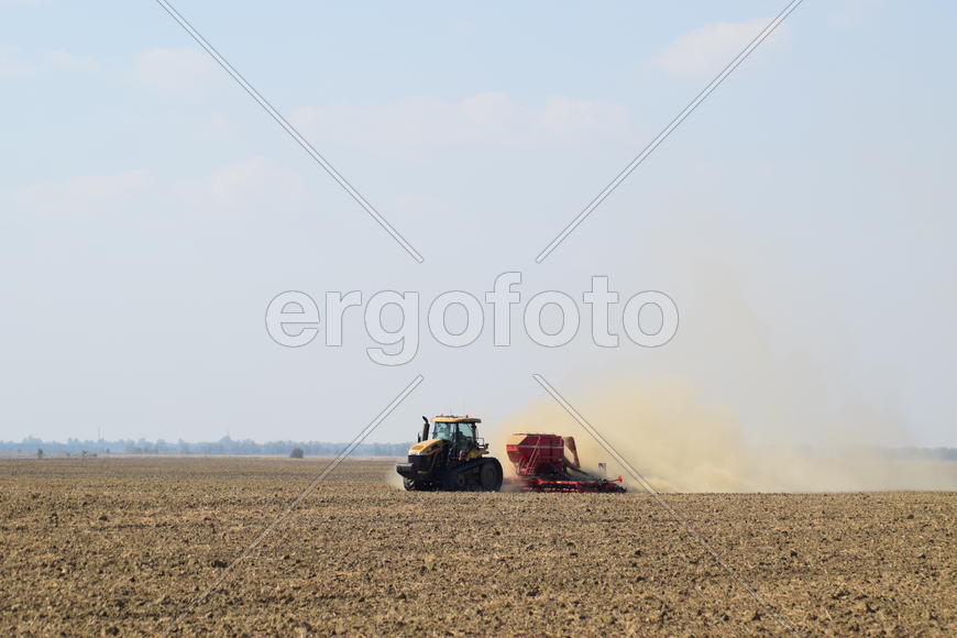 Russia, Temryuk - 19 July 2015: Tractor rides on the field and makes the fertilizer into the soil. C