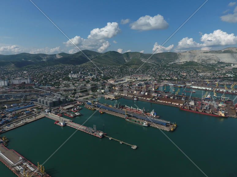 Industrial seaport, top view. Port cranes and cargo ships and barges. Loading and shipment of cargo 