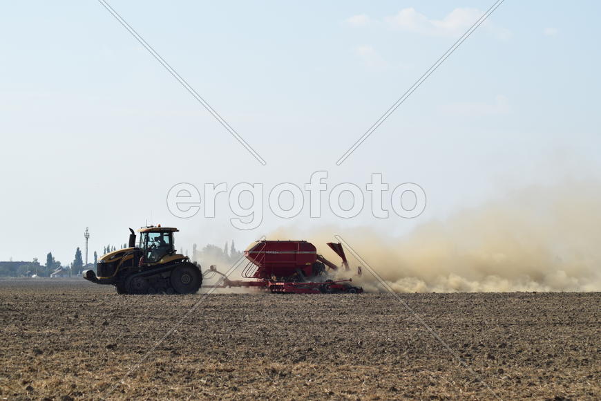 Russia, Temryuk - 19 July 2015: Tractor rides on the field and makes the fertilizer into the soil. C