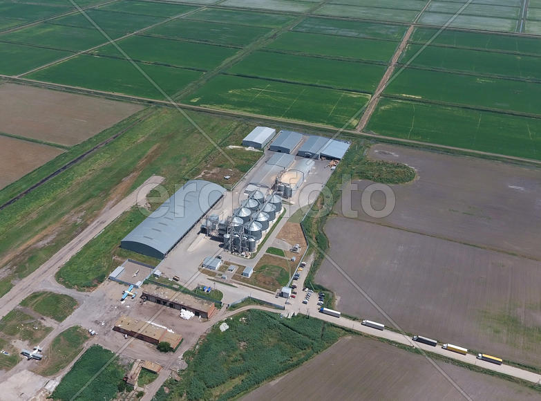 Plant for the drying and storage of grain. Rice plant in the middle of fields. Top view.