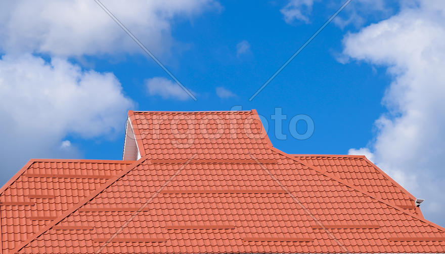 The roof of corrugated sheet red, orange. Roofing of metal profile wavy shape.
