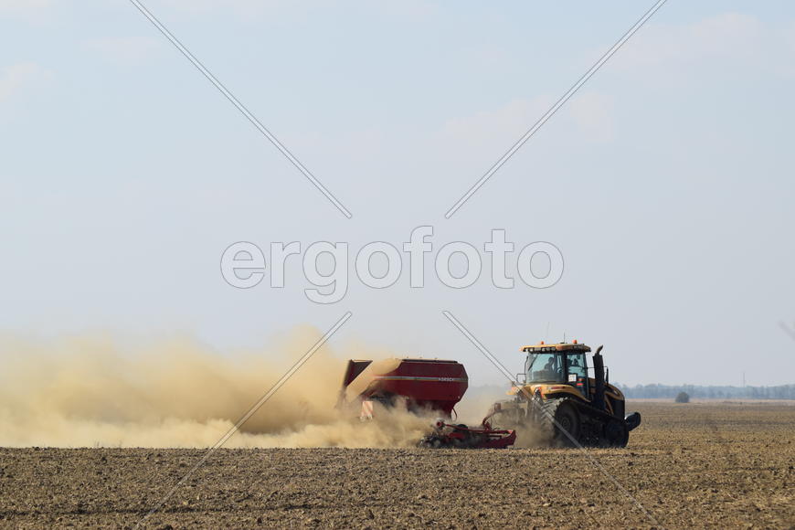 Russia, Temryuk - 19 July 2015: Tractor rides on the field and makes the fertilizer into the soil. C