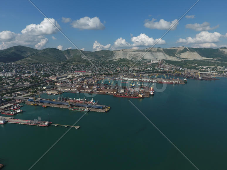 Industrial seaport, top view. Port cranes and cargo ships and barges. Loading and shipment of cargo 