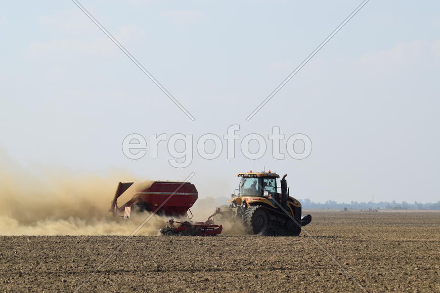 Russia, Temryuk - 19 July 2015: Tractor rides on the field and makes the fertilizer into the soil. C