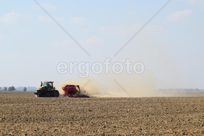 Russia, Temryuk - 19 July 2015: Tractor rides on the field and makes the fertilizer into the soil. C
