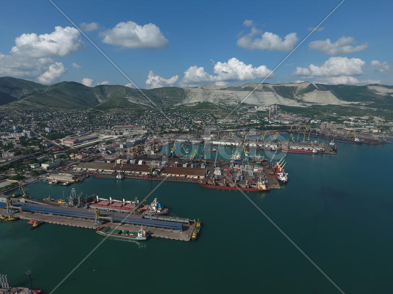 Industrial seaport, top view. Port cranes and cargo ships and barges. Loading and shipment of cargo 