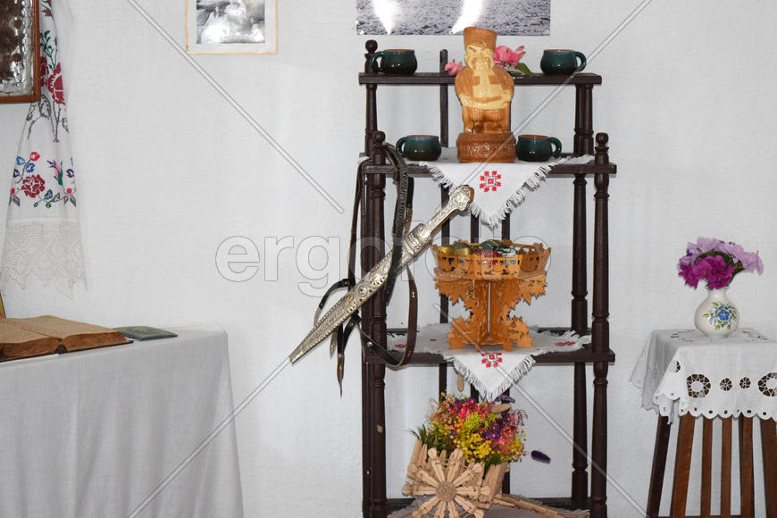 Именная сабля висящая на старинной деревянной этажерке 