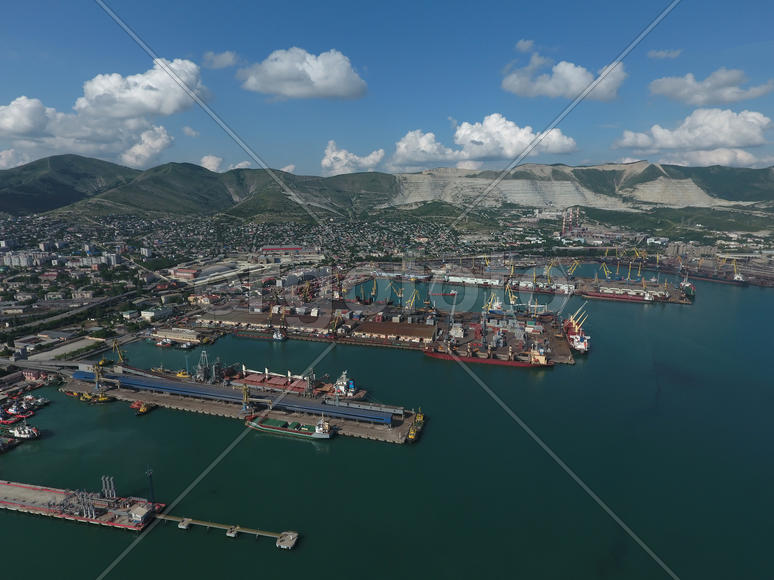 Industrial seaport, top view. Port cranes and cargo ships and barges. Loading and shipment of cargo 