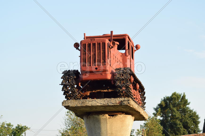 Russia, Temryuk - 15 July 2015: Tractor on a pedestal. Monument agricultural machinery.
