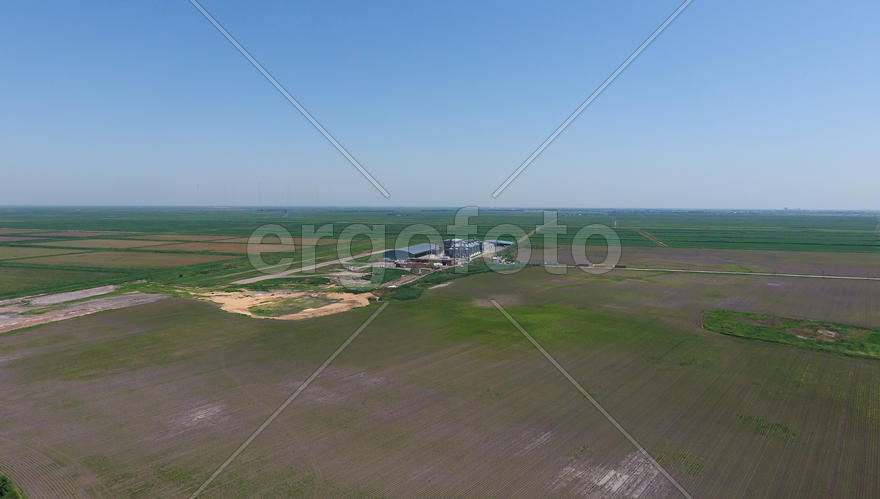 Plant for the drying and storage of grain. Rice plant in the middle of fields. Top view.