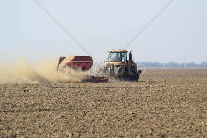 Russia, Temryuk - 19 July 2015: Tractor rides on the field and makes the fertilizer into the soil. C