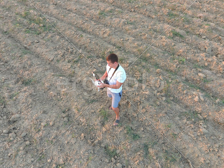 Мужчина держит в руках пульт дистанционного управления от квадрокоптера