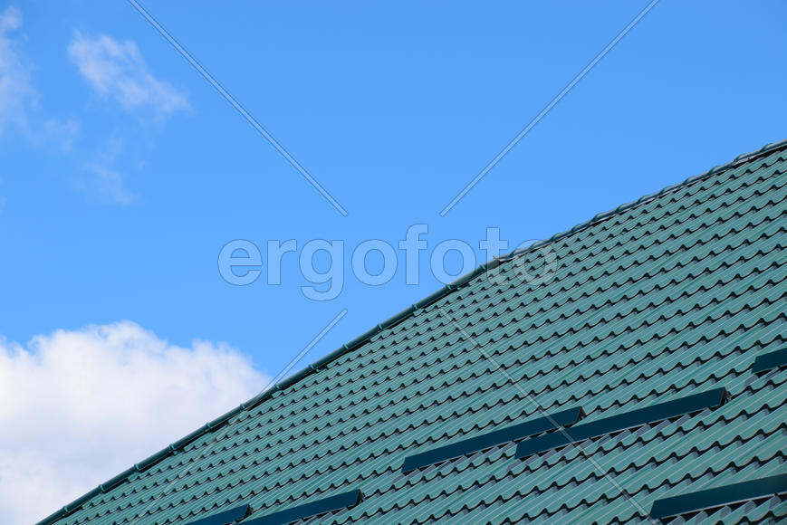 The roof of corrugated green sheet. Roofing of metal profile wavy shape.