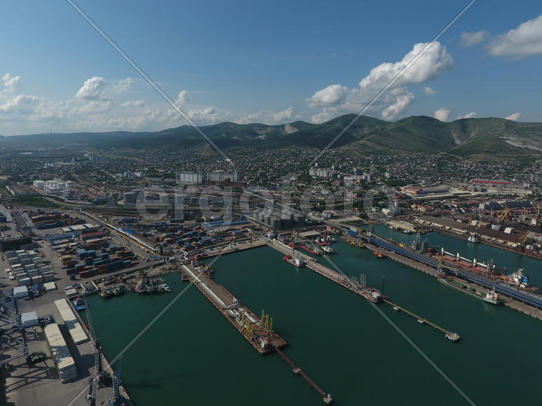 Industrial seaport, top view. Port cranes and cargo ships and barges. Loading and shipment of cargo 