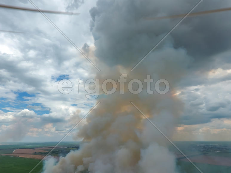 Quadrocopters propellers on the background of the smoke. Burning straw in the field.