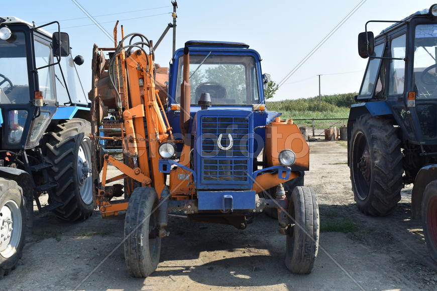 Tractor, standing in a row. Agricultural machinery. Parking of agricultural machinery.
