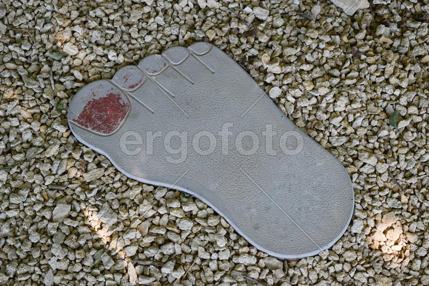 Tile in the form of foot of the person. A footpath in park
