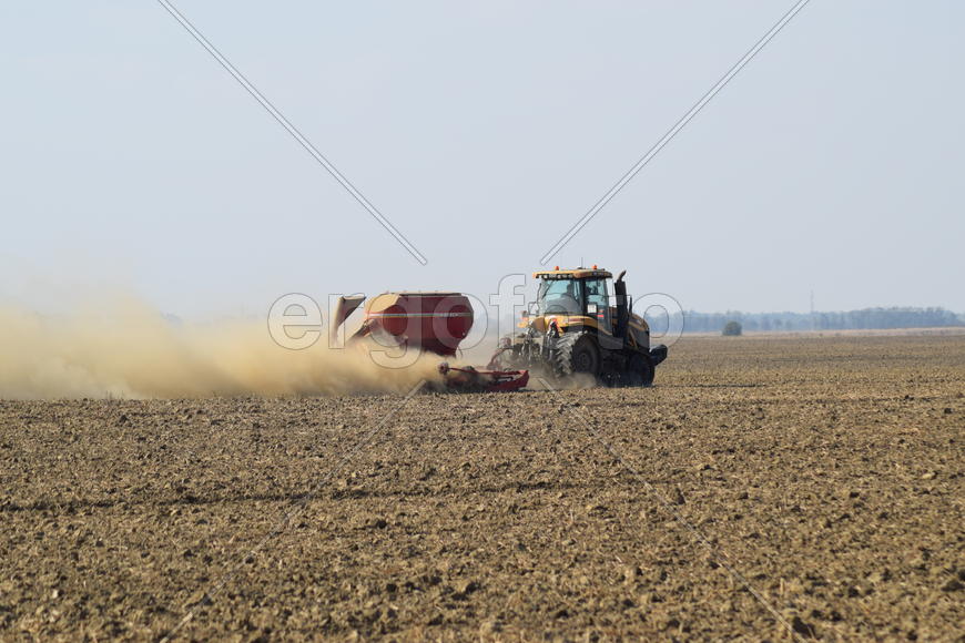 Russia, Temryuk - 19 July 2015: Tractor rides on the field and makes the fertilizer into the soil. C