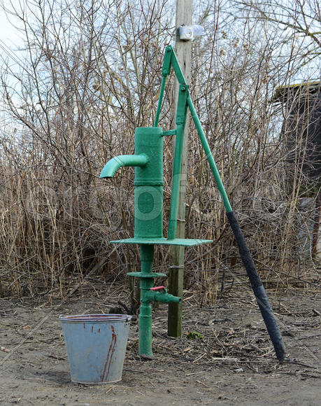 Hand pump leading to an artesian well. Pumping water for watering the garden