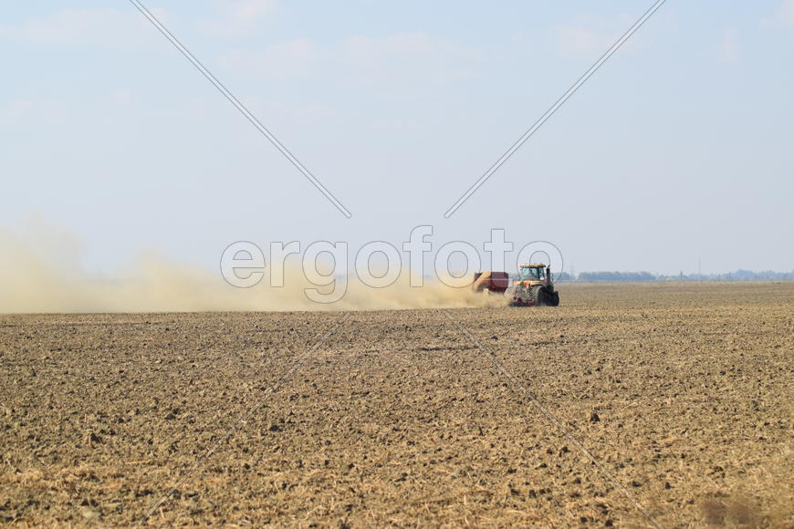 Russia, Temryuk - 19 July 2015: Tractor rides on the field and makes the fertilizer into the soil. C