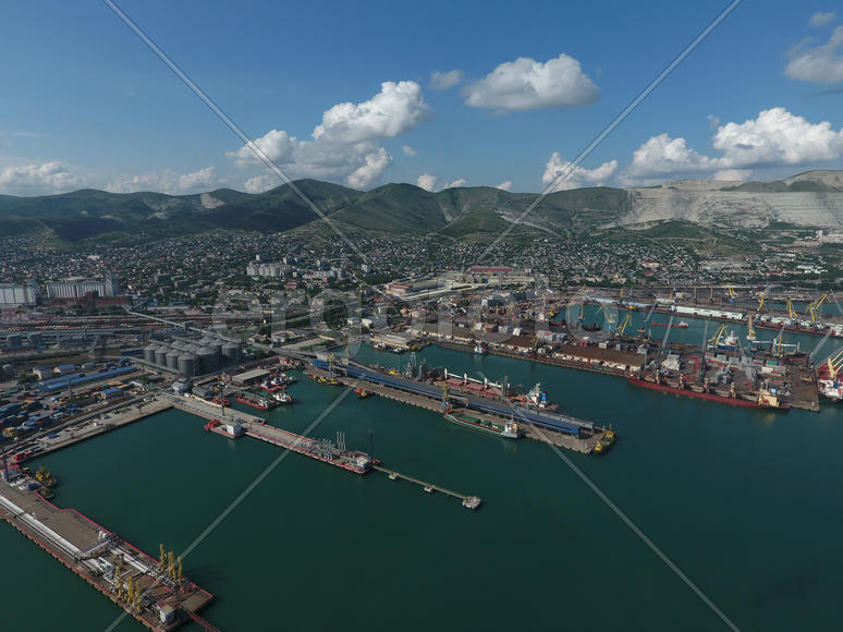 Industrial seaport, top view. Port cranes and cargo ships and barges. Loading and shipment of cargo 