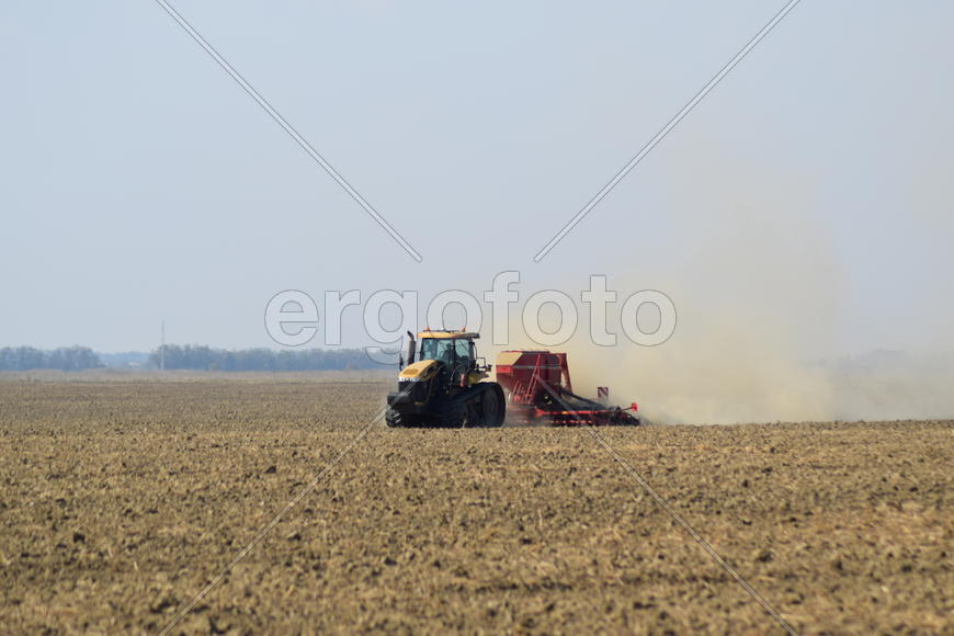 Russia, Temryuk - 19 July 2015: Tractor rides on the field and makes the fertilizer into the soil. C