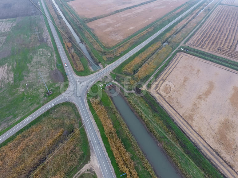 Перекресток асфальтированных дорог через поля. Вид сверху.