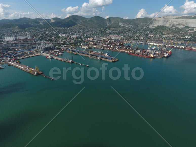 Industrial seaport, top view. Port cranes and cargo ships and barges. Loading and shipment of cargo 