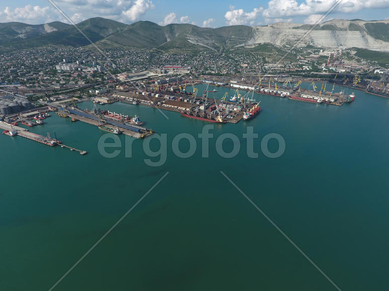 Industrial seaport, top view. Port cranes and cargo ships and barges. Loading and shipment of cargo 