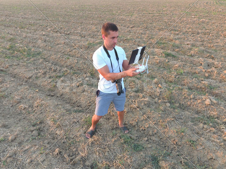 Мужчина держит в руках пульт дистанционного управления от квадрокоптера