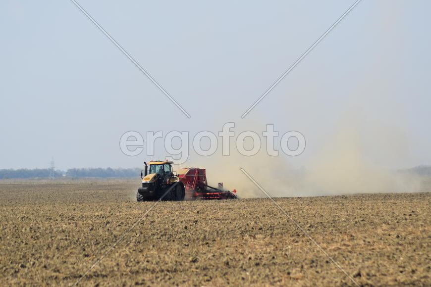 Russia, Temryuk - 19 July 2015: Tractor rides on the field and makes the fertilizer into the soil. C