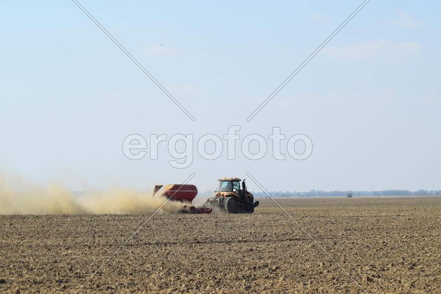 Russia, Temryuk - 19 July 2015: Tractor rides on the field and makes the fertilizer into the soil. C