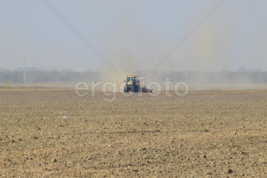 Russia, Temryuk - 19 July 2015: Tractor rides on the field and makes the fertilizer into the soil. C