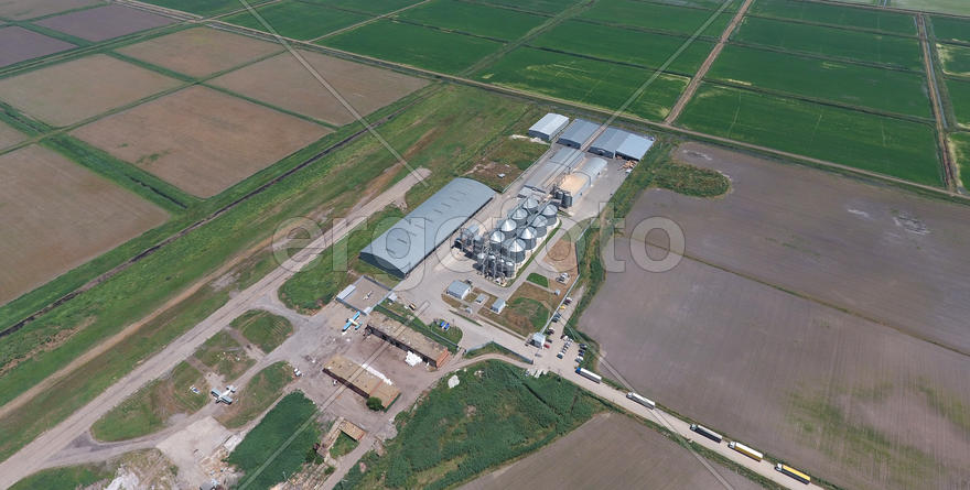 Plant for the drying and storage of grain. Rice plant in the middle of fields. Top view.