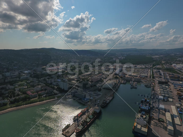 Industrial seaport, top view. Port cranes and cargo ships and barges. Loading and shipment of cargo 