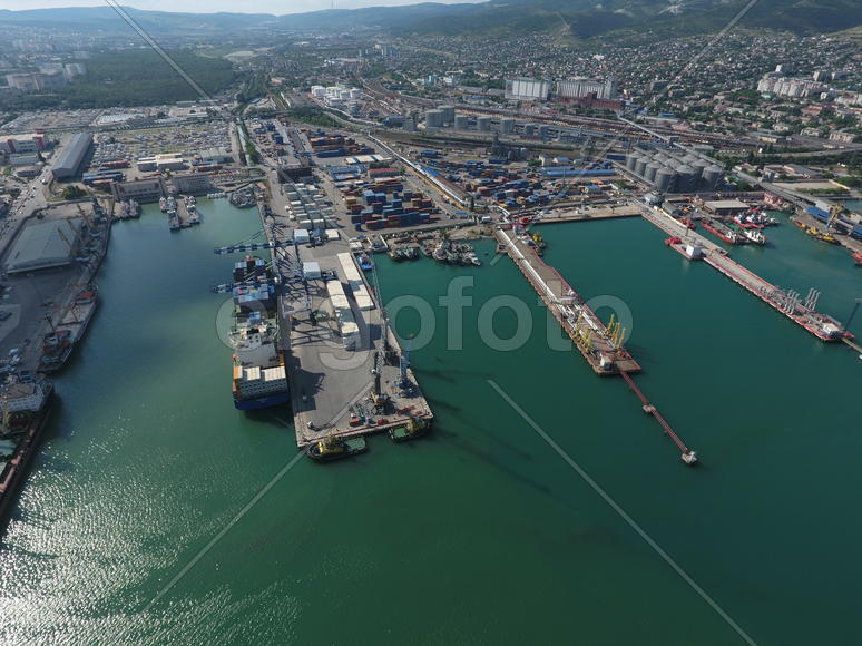 Industrial seaport, top view. Port cranes and cargo ships and barges. Loading and shipment of cargo 