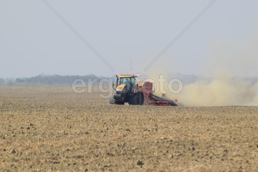 Russia, Temryuk - 19 July 2015: Tractor rides on the field and makes the fertilizer into the soil. C