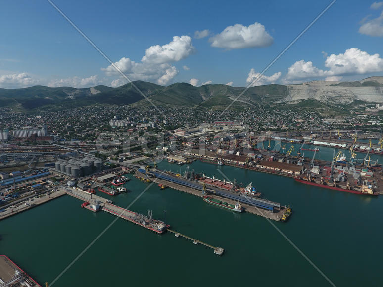 Industrial seaport, top view. Port cranes and cargo ships and barges. Loading and shipment of cargo 