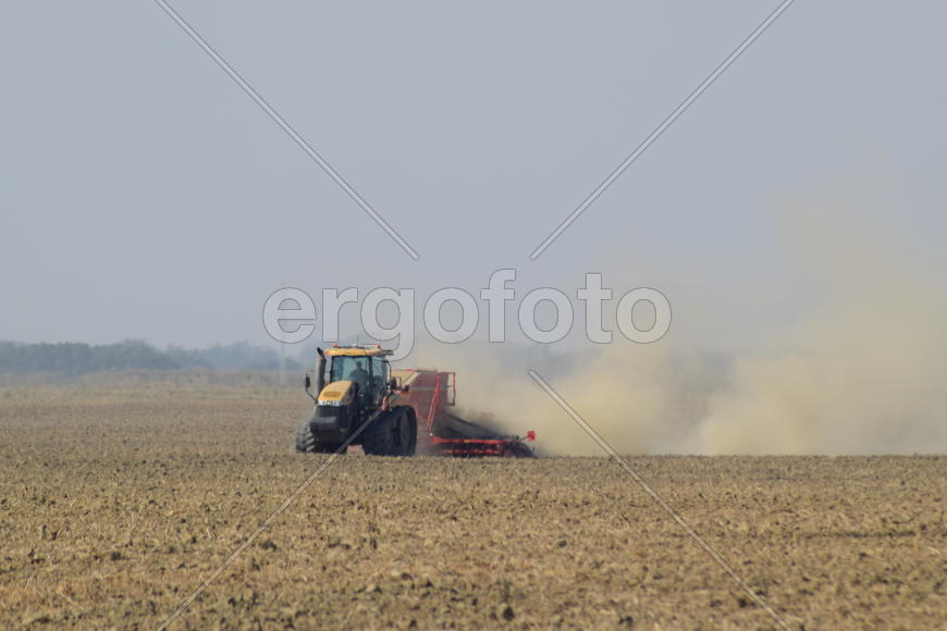 Russia, Temryuk - 19 July 2015: Tractor rides on the field and makes the fertilizer into the soil. C