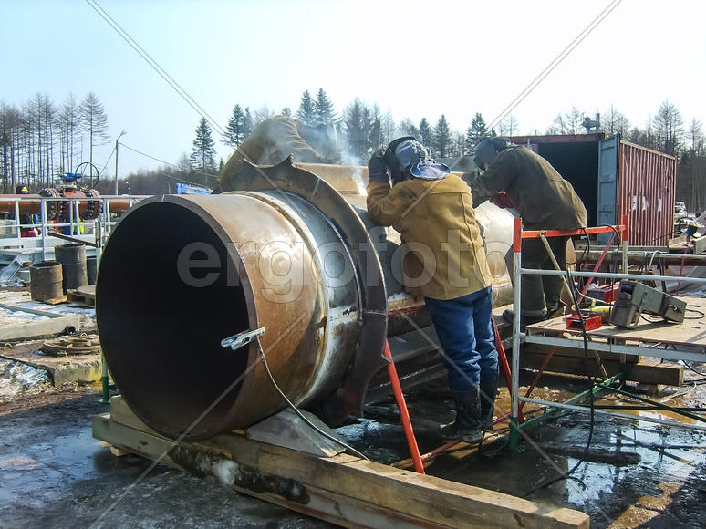 Сварка и монтаж трубопровода. Сварщики промышленные рабочие и монтажники.