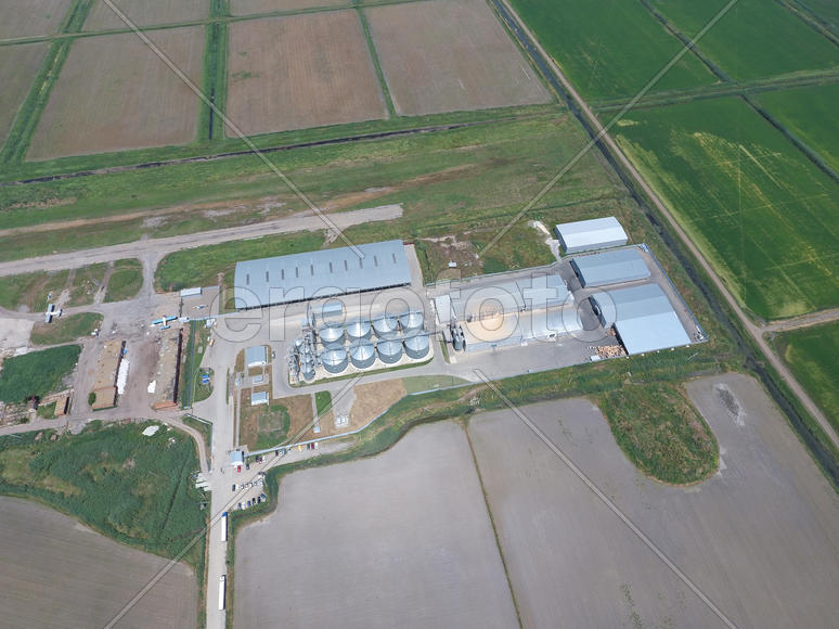 Plant for the drying and storage of grain. Rice plant in the middle of fields. Top view.